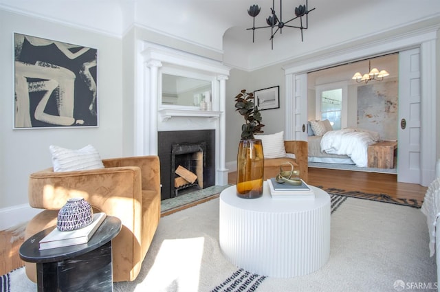 living room featuring a chandelier, a fireplace, and wood finished floors