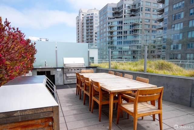 view of patio featuring area for grilling, sink, and a grill