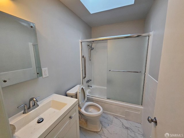 full bathroom featuring vanity, a skylight, toilet, and bath / shower combo with glass door