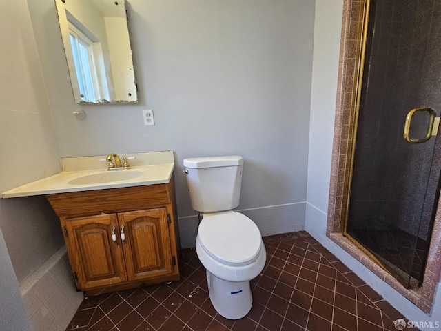 bathroom featuring tile patterned floors, vanity, toilet, and a shower with door