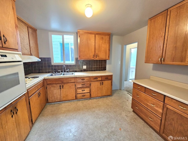 kitchen featuring decorative backsplash, sink, and white appliances