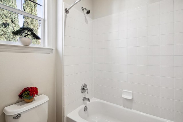 bathroom featuring toilet and tiled shower / bath