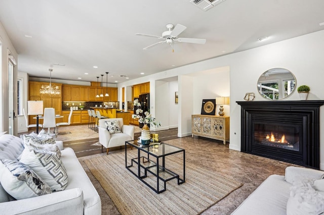 living room with ceiling fan with notable chandelier