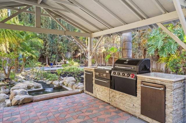 view of patio featuring a gazebo, exterior kitchen, and area for grilling