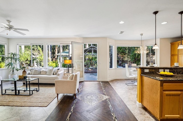 living room with ceiling fan with notable chandelier and parquet floors