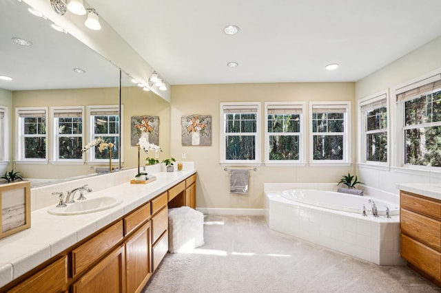 bathroom with tiled tub and vanity