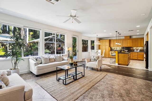 tiled living room featuring sink, ceiling fan, and a wealth of natural light