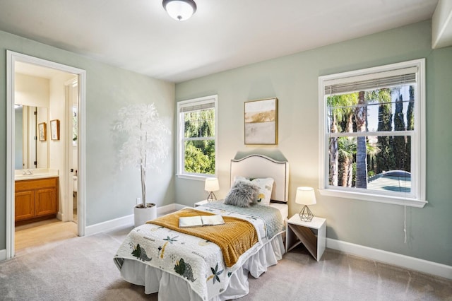 carpeted bedroom with sink and ensuite bath