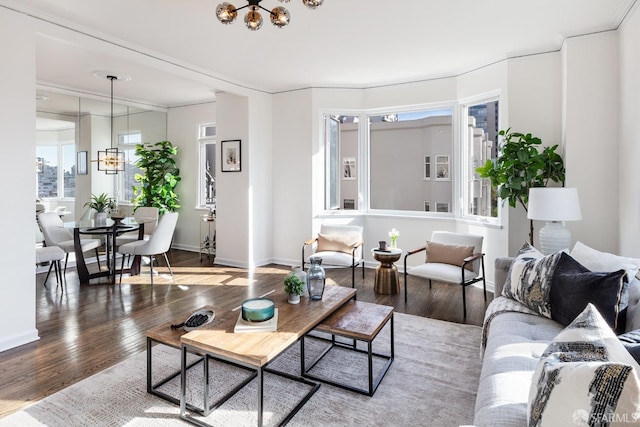 living room featuring a chandelier, wood-type flooring, and ornamental molding