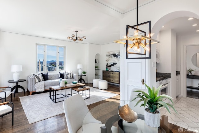 living room with hardwood / wood-style floors, crown molding, and an inviting chandelier