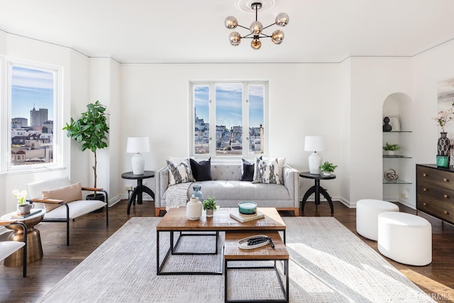 living room with built in shelves, dark hardwood / wood-style flooring, and a notable chandelier