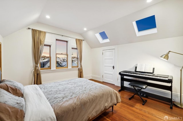 bedroom with lofted ceiling with skylight and hardwood / wood-style floors