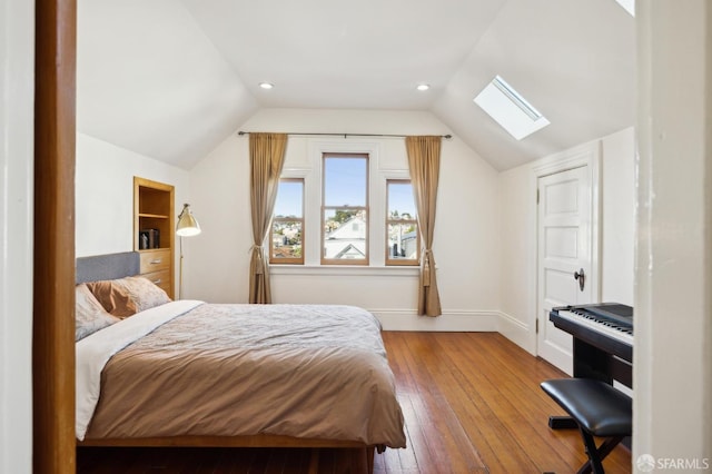 bedroom with hardwood / wood-style floors and vaulted ceiling with skylight