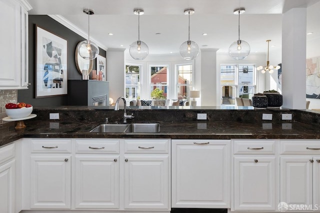 kitchen featuring white cabinetry, sink, and pendant lighting