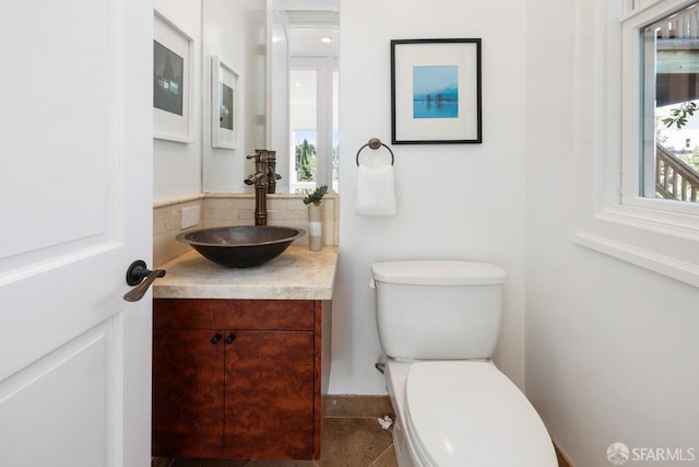 bathroom with vanity, a healthy amount of sunlight, and toilet