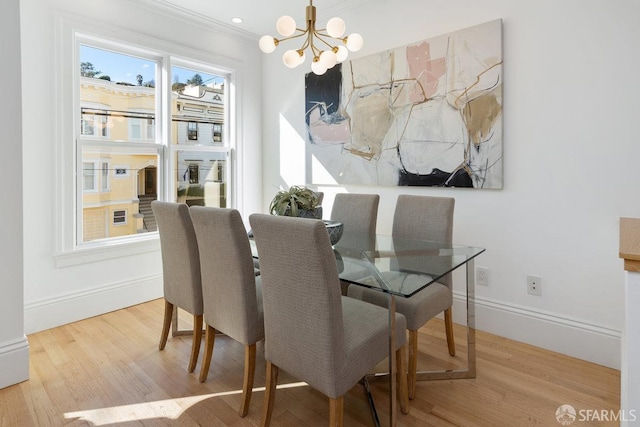 dining area featuring ornamental molding, a chandelier, and hardwood / wood-style floors