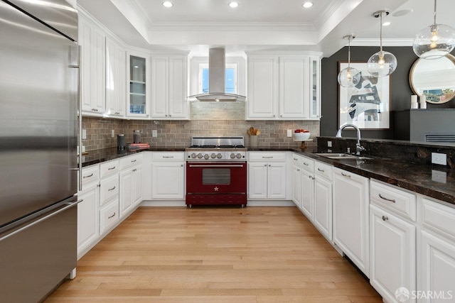 kitchen featuring sink, stainless steel built in refrigerator, extractor fan, range with gas stovetop, and white cabinets