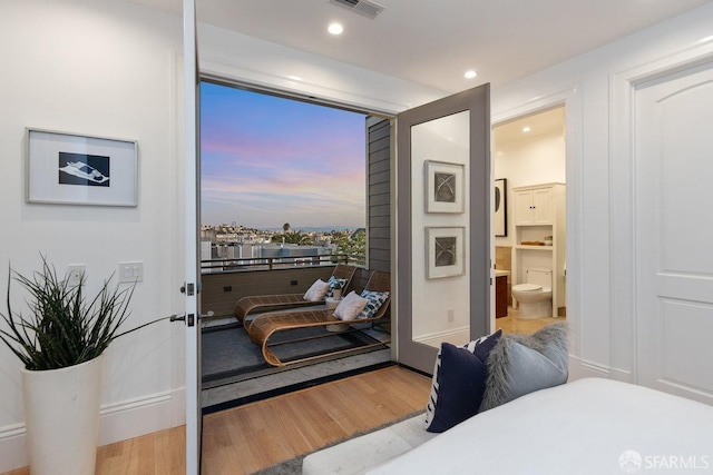 bedroom featuring hardwood / wood-style floors and ensuite bathroom