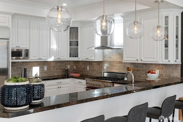 kitchen featuring white cabinetry, hanging light fixtures, and high quality appliances