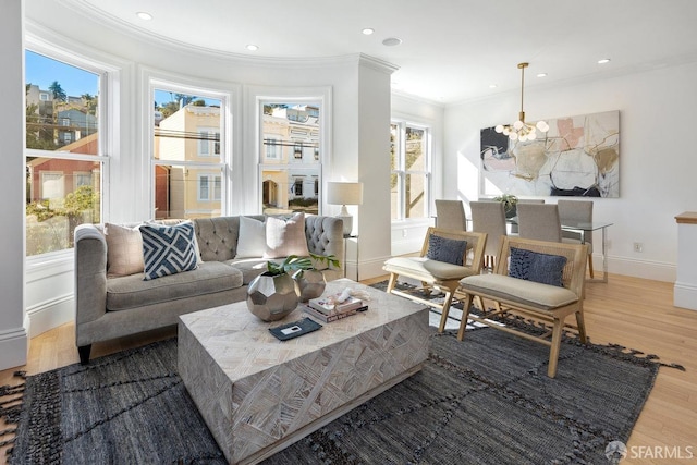 living room featuring hardwood / wood-style flooring, crown molding, and an inviting chandelier