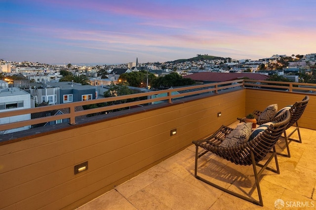 patio terrace at dusk featuring a balcony