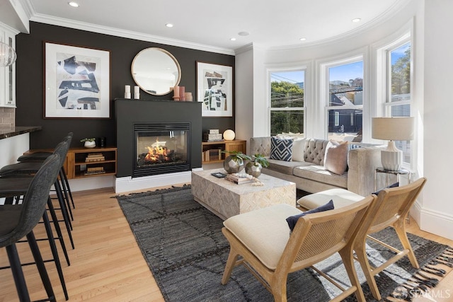 living room with crown molding, a multi sided fireplace, and light hardwood / wood-style floors