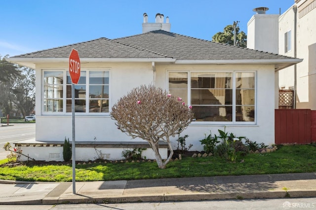 view of property exterior featuring roof with shingles, fence, and stucco siding