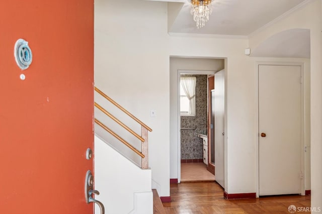 foyer featuring crown molding, baseboards, and stairs