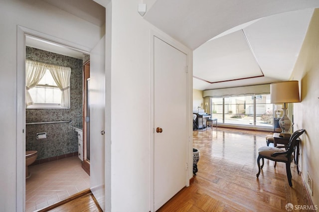 hallway with baseboards and wallpapered walls