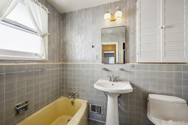 full bath featuring toilet, visible vents, a bathtub, and tile walls