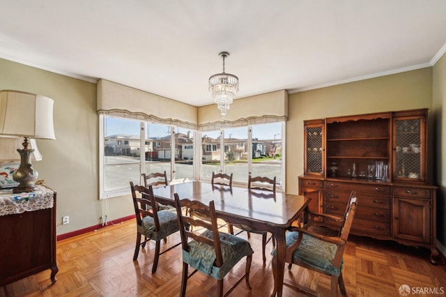 dining space with crown molding, a residential view, baseboards, and a notable chandelier