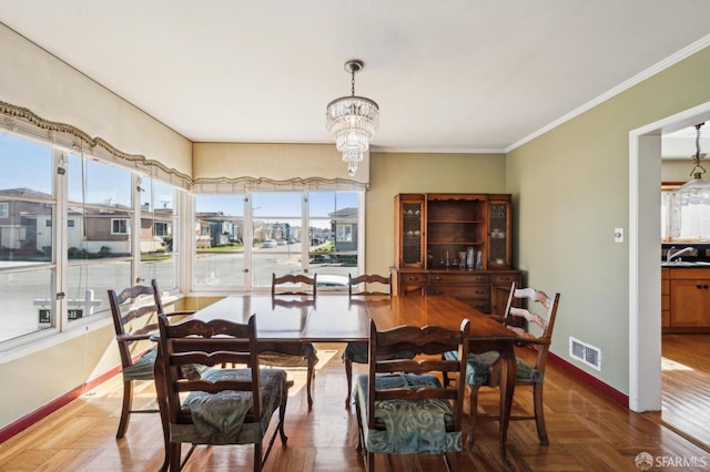 dining area featuring a chandelier, a healthy amount of sunlight, visible vents, and baseboards