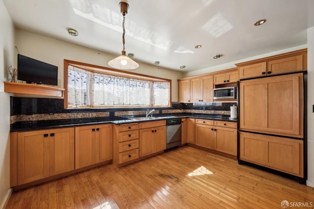 kitchen with light wood-type flooring, dark countertops, tasteful backsplash, and stainless steel appliances