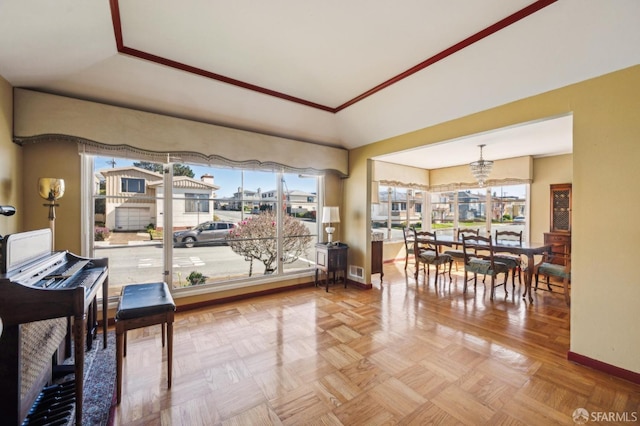 interior space with a tray ceiling, an inviting chandelier, visible vents, and baseboards