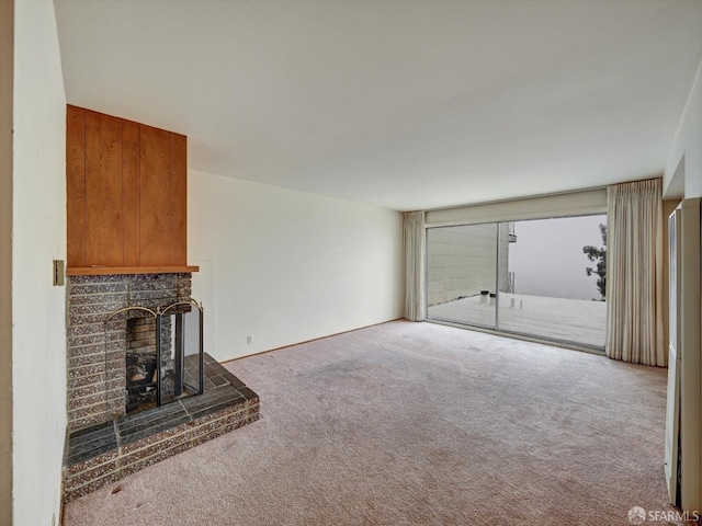 unfurnished living room featuring carpet and a brick fireplace