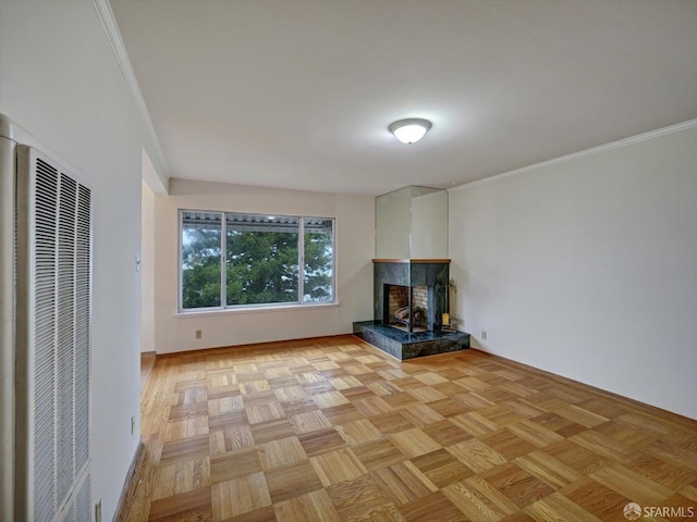 unfurnished living room with light parquet floors, crown molding, and a fireplace