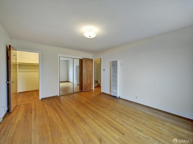 unfurnished bedroom featuring two closets and light wood-type flooring