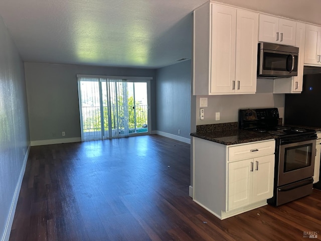 kitchen featuring stainless steel appliances, dark stone counters, white cabinets, and dark hardwood / wood-style floors