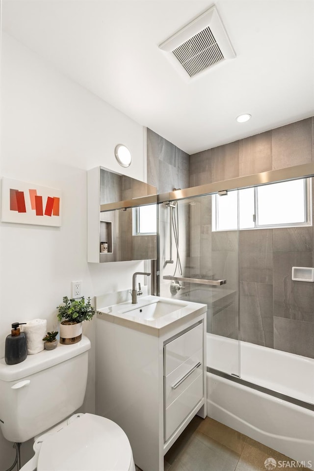 full bath with visible vents, toilet, shower / bath combination with glass door, tile patterned flooring, and vanity