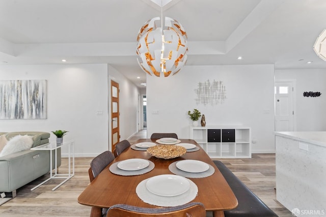 dining area featuring a tray ceiling, recessed lighting, an inviting chandelier, light wood-style floors, and baseboards