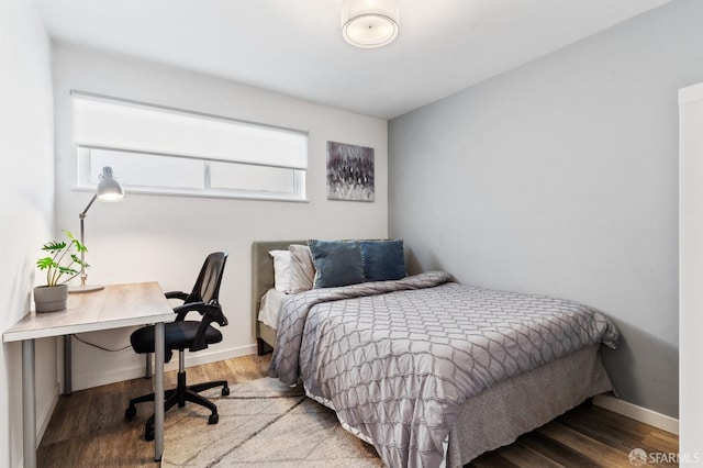 bedroom with baseboards and wood finished floors