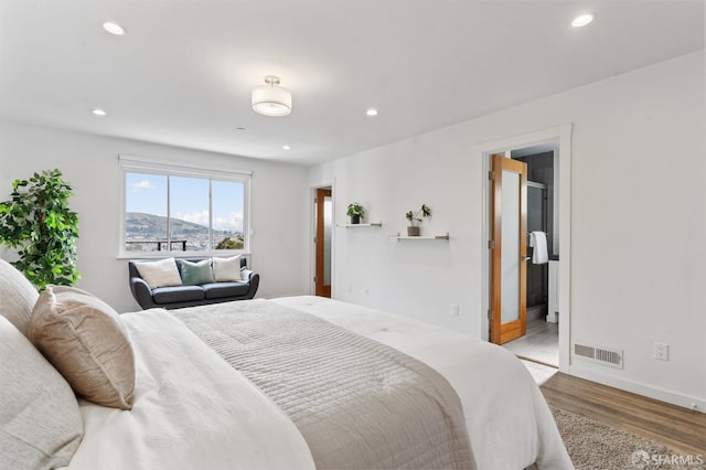 bedroom featuring a mountain view, recessed lighting, wood finished floors, visible vents, and baseboards