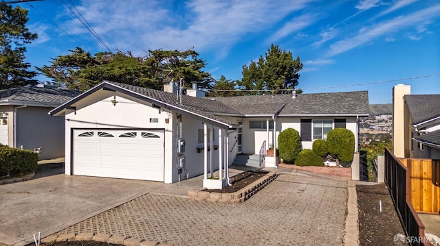 ranch-style home featuring concrete driveway, a chimney, an attached garage, fence, and stucco siding