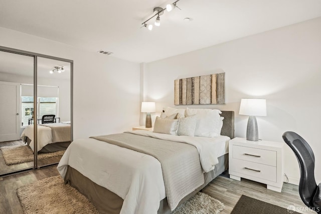 bedroom featuring a closet, wood finished floors, and visible vents