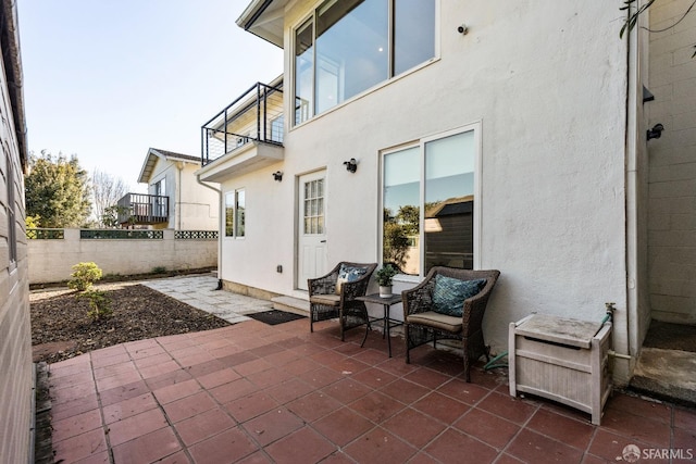 view of patio / terrace featuring fence and a balcony