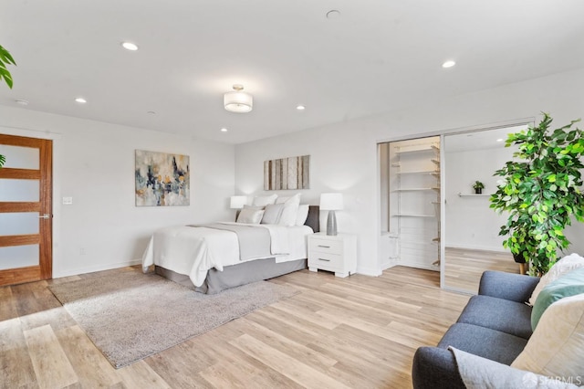 bedroom featuring baseboards, a closet, light wood-type flooring, and recessed lighting