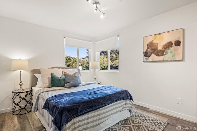 bedroom with baseboards and wood finished floors