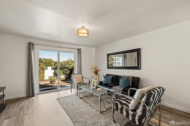 living area with baseboards and wood finished floors