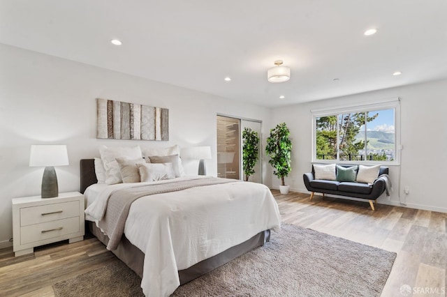 bedroom featuring light wood finished floors, baseboards, and recessed lighting