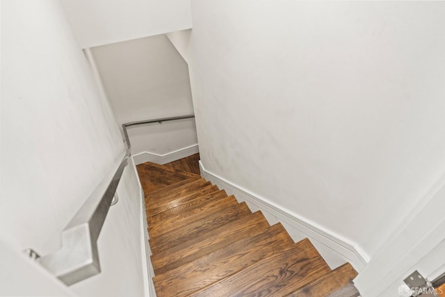 stairway featuring wood finished floors and baseboards